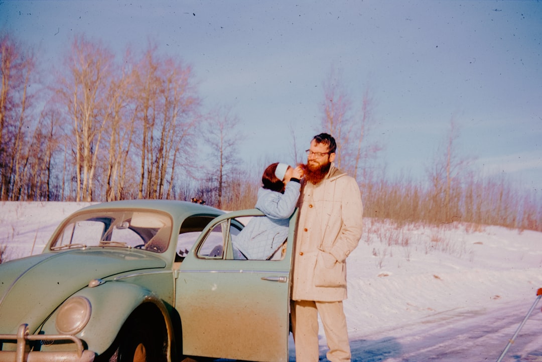 un-homme-debout-a-cote-dune-voiture-dans-la-neige-WHvZE1Mdu6M