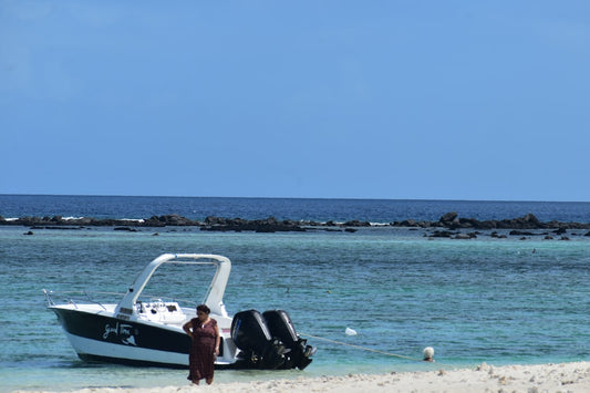 un-homme-debout-sur-une-plage-a-cote-dun-bateau--XBHsa4pxjA