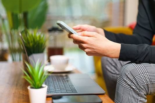 une-personne-assise-sur-un-canape-a-laide-dun-telephone-cellulaire-bKqUsKQDqtU