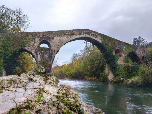 un-pont-de-pierre-sur-une-riviere-entouree-darbres-IYHNet74RPU