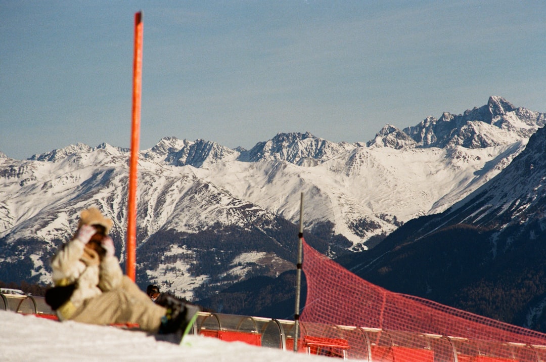 une-personne-assise-dans-la-neige-au-sommet-dune-montagne-N5YGRFdRzaM